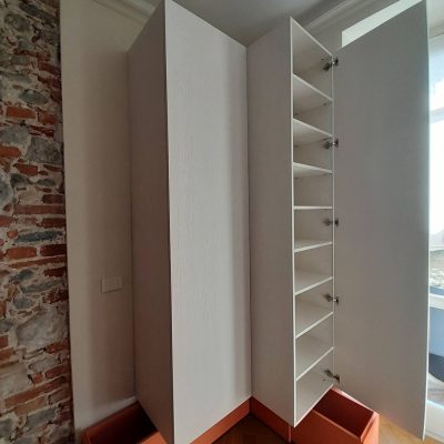 Armadio a doppio corpo ad angolo con effetto sospeso interno.